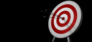 A close-up image of a target with three arrows hitting the bullseye, symbolizing precision and success in achieving goals. The background is black, creating a sharp contrast with the red and white target, highlighting focus and accuracy.