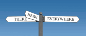 Photo of a three-way street sign against a clear blue sky, with arrows labeled 'Here,' 'There,' and 'Everywhere,' symbolizing broad visibility and holistic search optimization.