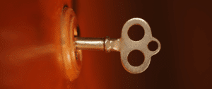 A close-up photo of a vintage brass key inserted into a keyhole, with a warm, blurred background. The image symbolizes unlocking new opportunities and digital success through holistic-search optimization.