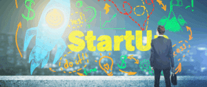 Business professional facing a colorful wall of startup-themed doodles and the word “StartUp,” symbolizing entrepreneurship, growth strategy, and launching a new business.