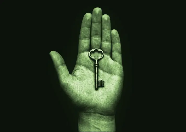 An open hand holding a single brass key.